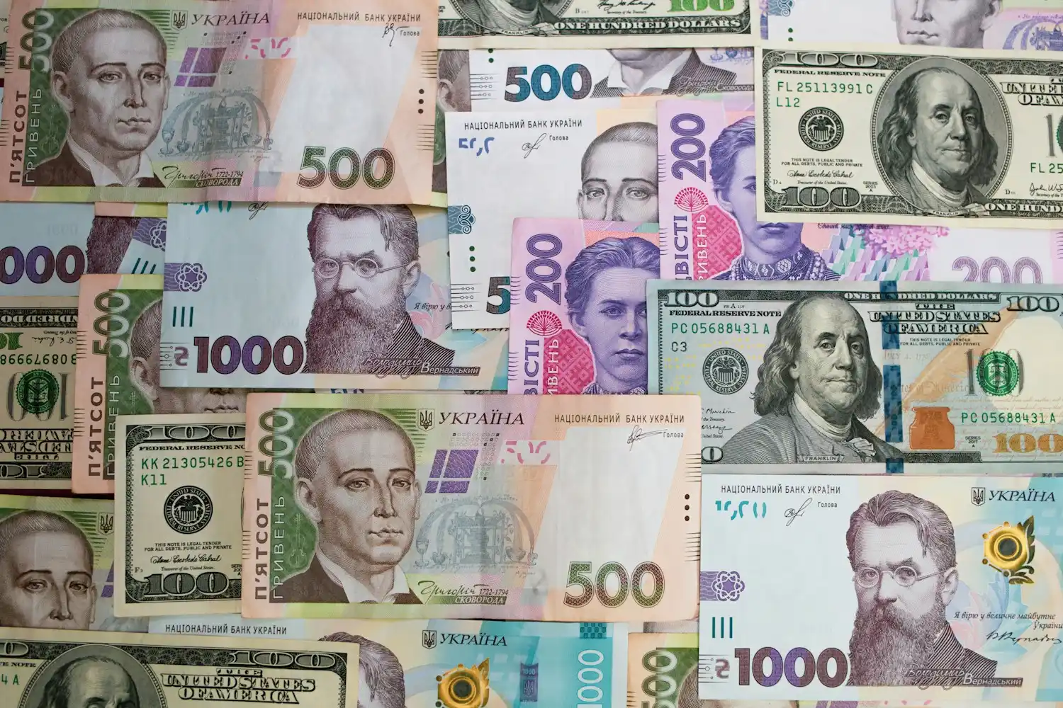 Гривневі та валютні банкноти поряд із документами — ілюстрація до матеріалу про валютні розрахунки за зовнішньоекономічними контрактами