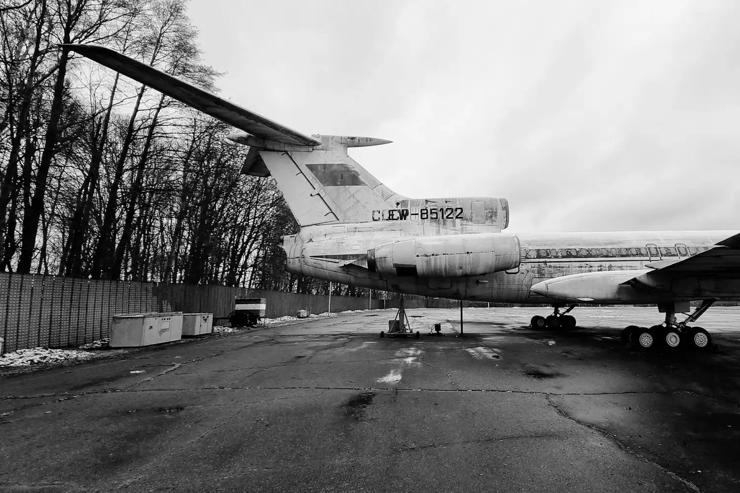 An old passenger jet standing idle behind a concrete fence — illustration for a case on the seizure of aircraft