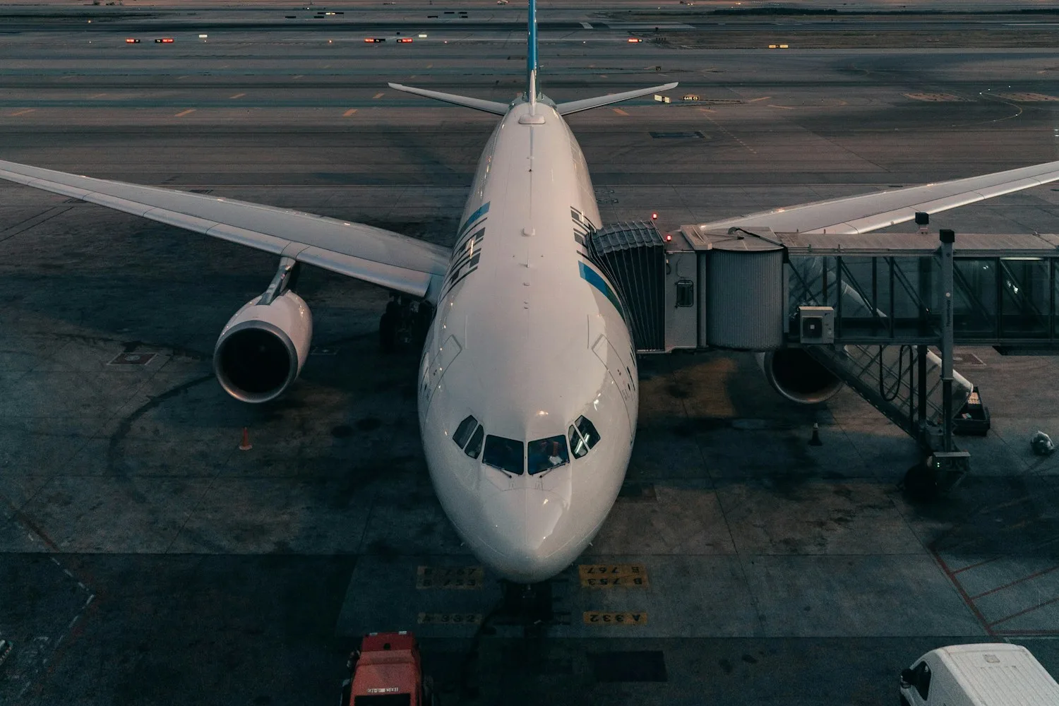 A widebody airliner parked at a jet bridge at dusk — illustration for a piece on insurance for restarting flights in Ukraine