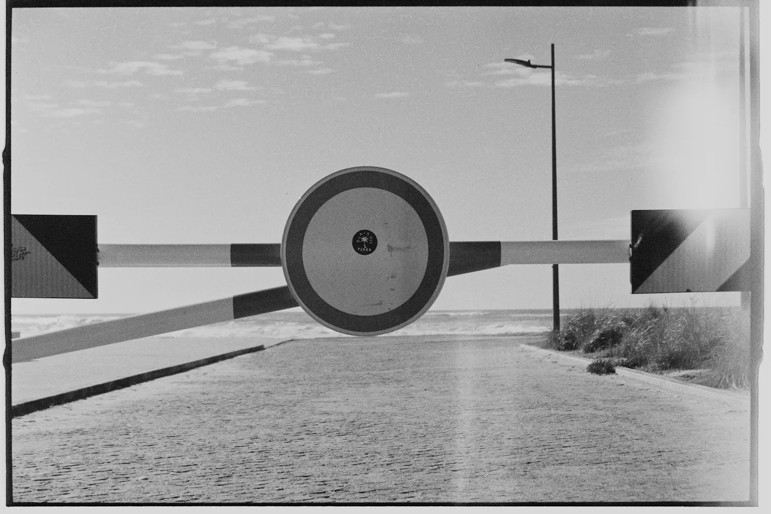 Black-and-white photograph of a closed road barrier with a no-entry sign across an empty road — the missing conflict-of-laws instrument between Ukraine and the EU