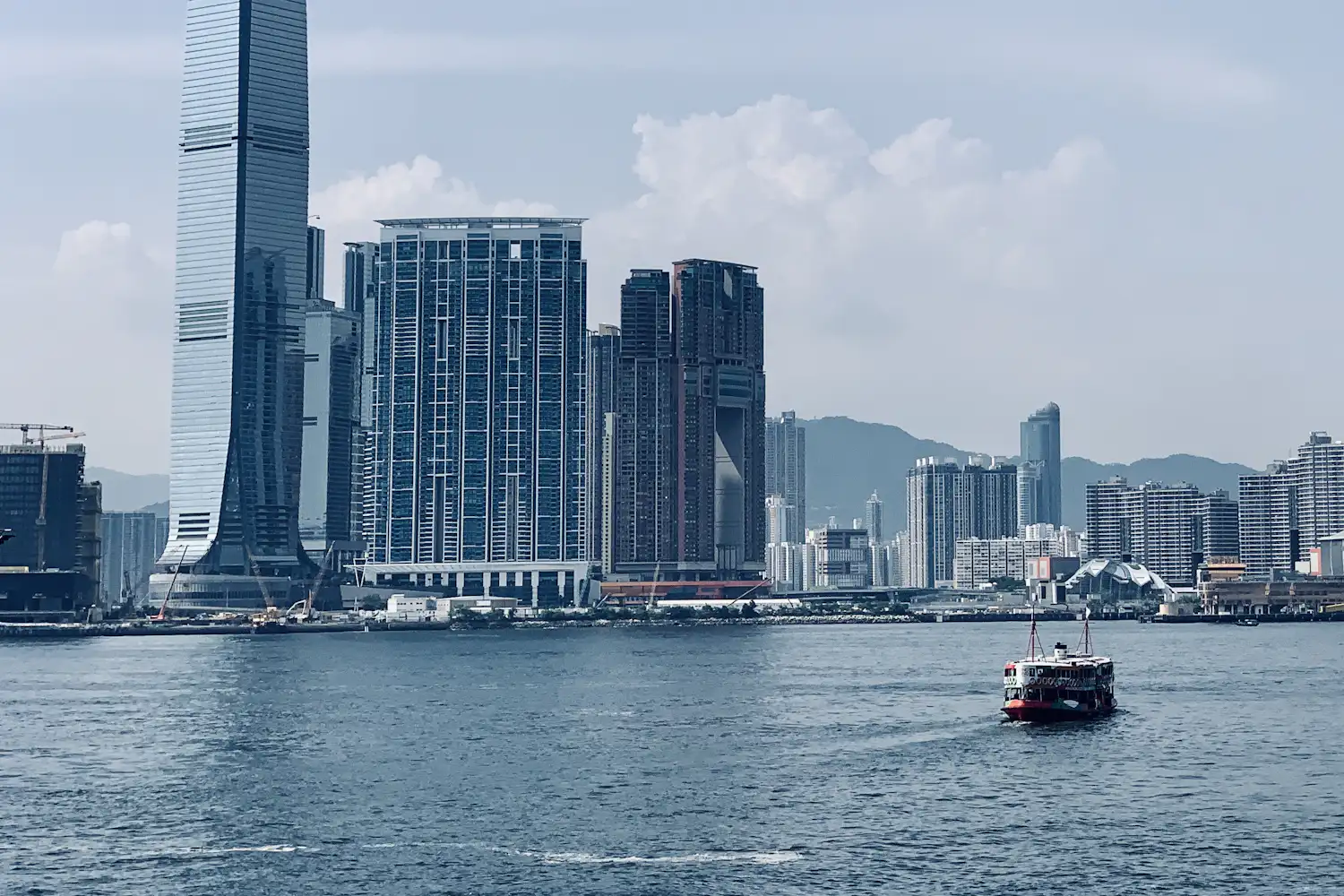 Пором Star Ferry перетинає гавань Вікторія на тлі хмарочосів Коулуна